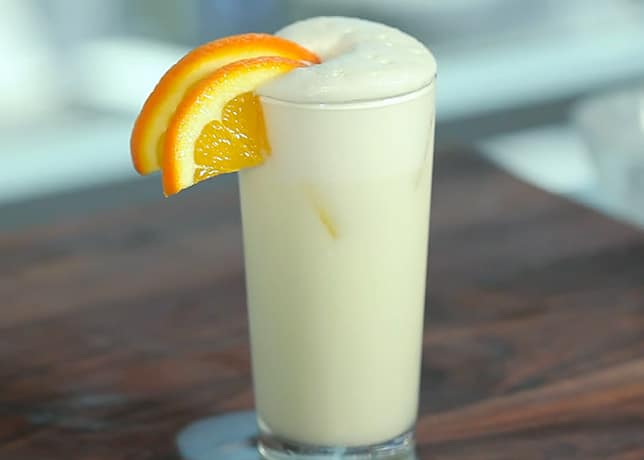 Un Ramos Gin Fizz garni de deux tranches d'orange