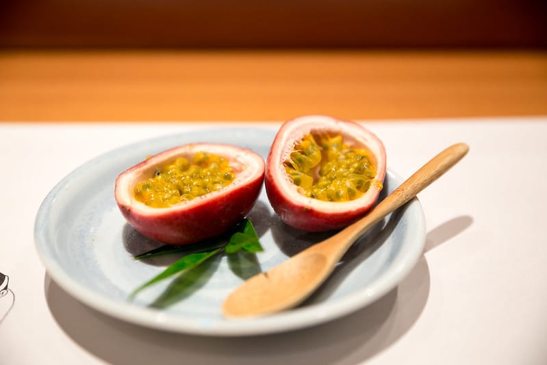 Deux coques de fruits de la passion et une cuillère en bois