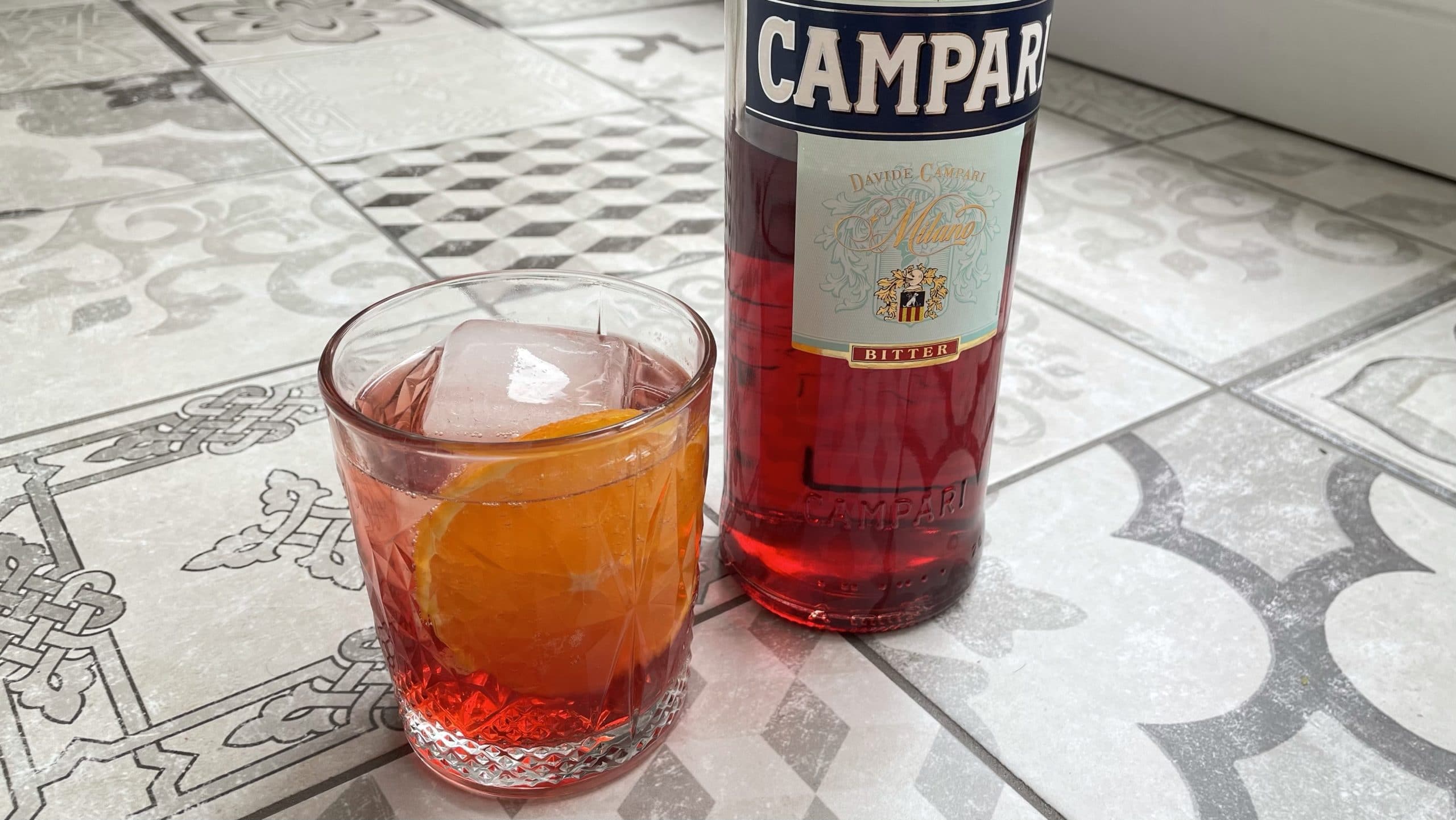 Un Campari Soda à côté d'une bouteille de Campari