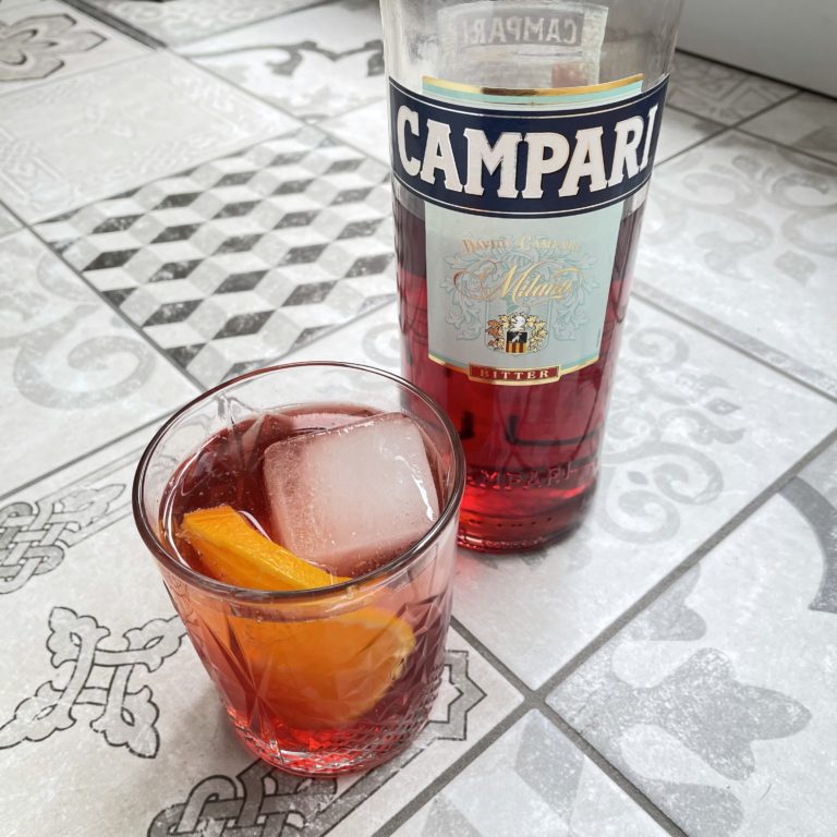 Un Campari Soda à côté d'une bouteille de Campari